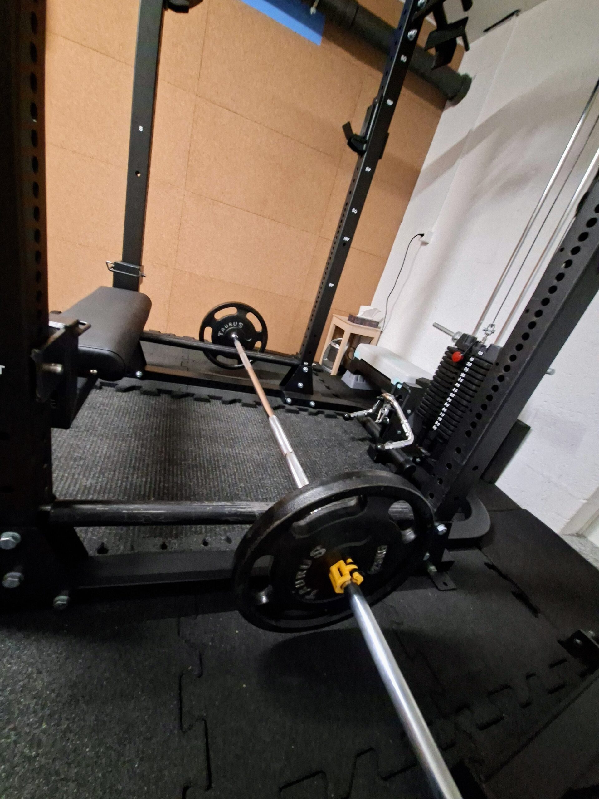 Barre chargée posée sur le rack, prête pour hip thrust, vue rapprochée des disques